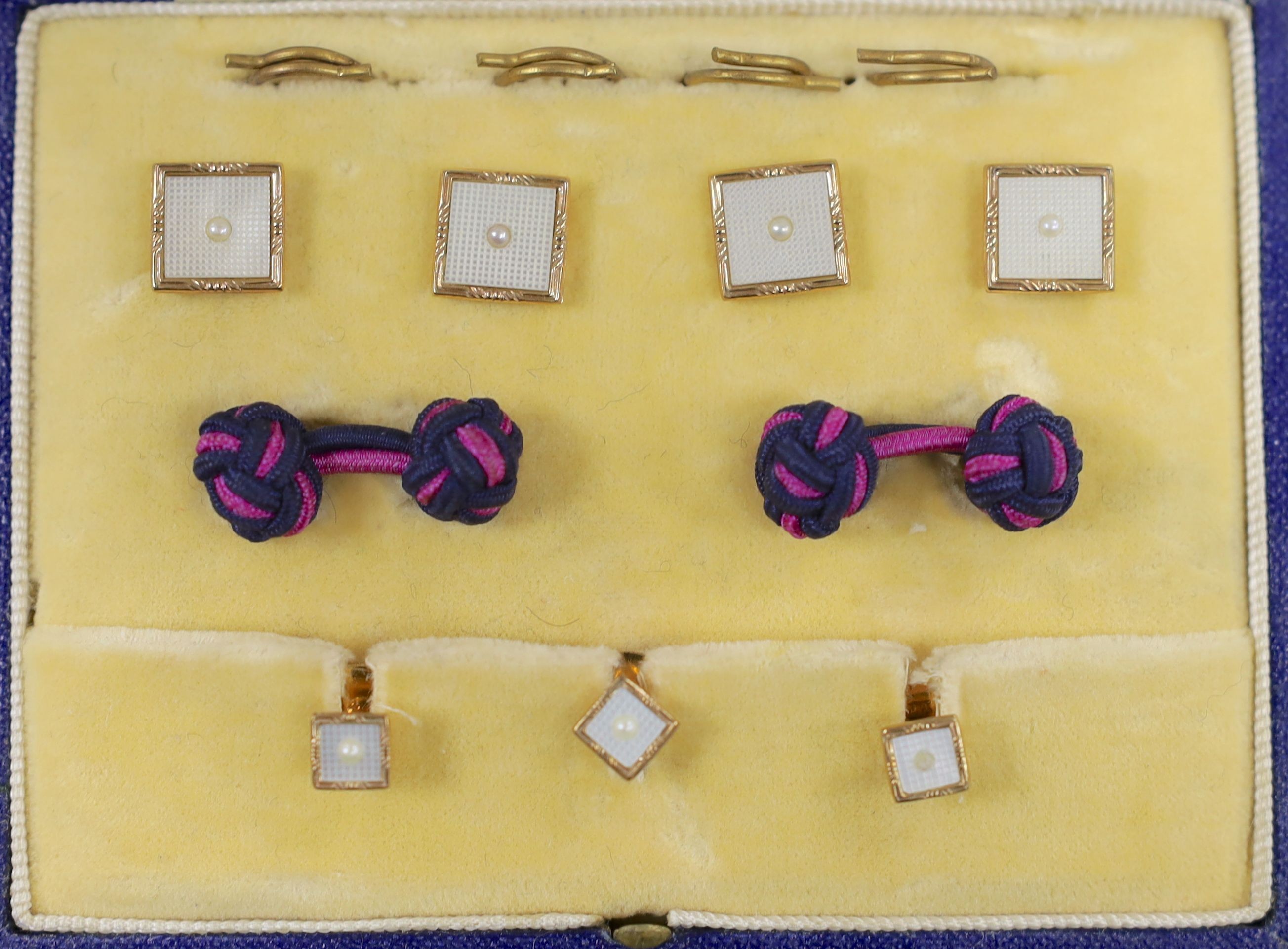 A modern cased seven (ex 9) piece 9ct gold, mother of pearl and seed pearl set dress stud set, gross 7.2 grams.